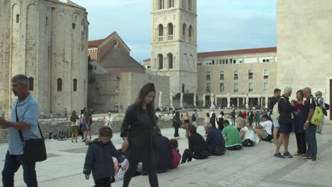 Centro-De-La-Ciudad-Vieja-De-Zadar,-Muchos-Turistas-Caminando-En-La-Plaza-De-La-Ciudad,-De-Mano,-Día