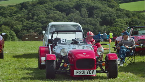 Two-Old-Men-Sitting-And-Talking-Next-To-A-Red-Caterham-Seven-Sports-Car