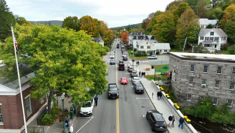 Aerial-tracking-shot-of-busy-main-street-in-quaint-small-town-in-fall