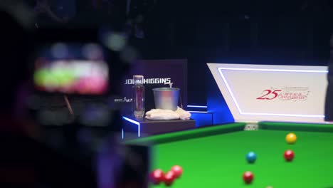 John-Higgins,-a-Scottish-professional-snooker-player,-rests-and-looks-on-at-a-play-between-sets-as-a-TV-camera-crosses-the-frame-during-a-match-of-the-Hong-Kong-Masters-snooker-tournament-event