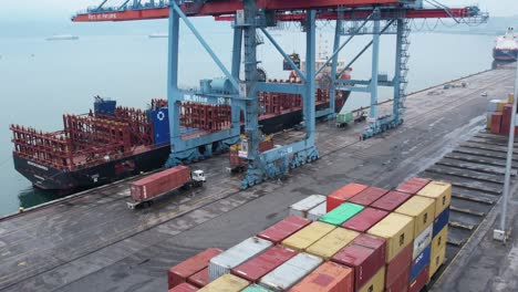 Luftbild-Eines-Im-Hafen-Gelagerten-Frachtcontainers-Mit-Kran,-Der-Darauf-Wartet,-Ein-Frachtschiff-In-Indonesien-Zu-Laden