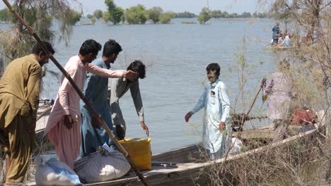 Los-Lugareños-Ayudando-Con-Ayuda-En-Barco-Junto-Al-Río-En-Sindh-Para-El-Alivio-De-Las-Inundaciones-En-Maher-En-Sindh
