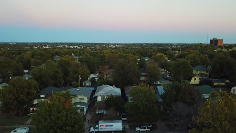 Descending-aerial-shot-over-a-residential-neighbourhood-during-sunset