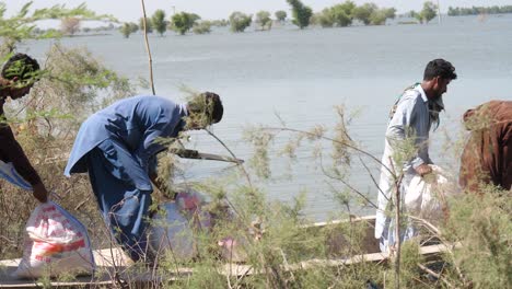 Einheimische-Helfen-Beim-Heben-Von-Booten-Neben-Dem-Fluss-In-Sindh-Für-Hochwasserhilfe-In-Maher-In-Sindh
