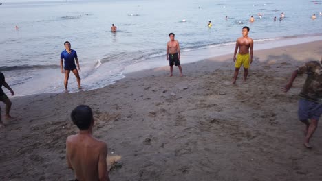 Eine-Gruppe-Männlicher-Vietnamesischer-Freunde,-Die-Am-Frühen-Morgen-Ihre-Fußball--Oder-Fußballkünste-An-Einem-Vietnamesischen-Strand-üben