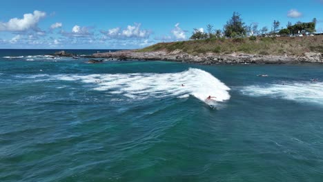 Athletic-surfer-riding-a-small-wave-at-Ho'okipa-Beach-in-North-Shore,-Maui