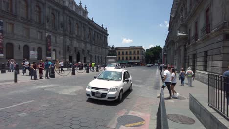 Una-De-Las-Calles-Del-Centro-De-La-Ciudad-De-México-Con-Vehículos-Pasando-Y-Turistas-Caminando