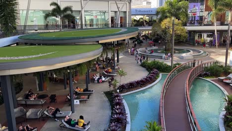 Handheld-motion-shot-capturing-shoppers-strolling-and-window-shopping-at-pacific-fairs-shopping-centre-in-Gold-Coast,-Broadbeach-Waters-on-a-relaxing-and-sunny-afternoon,-Queensland,-Australia