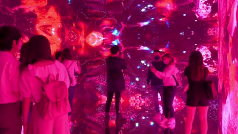 Chinese-art-visitors-are-seen-at-an-immersive-futuristic-art-installation-inspired-by-new-media-digital-such-as-NFT-Crypto-Art,-and-non-fungible-tokens,-as-part-of-the-new-trend-in-modern-art