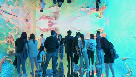 Chinese-visitors-are-seen-experiencing-an-immersive-art-installation-inspired-by-new-media-digital-such-as-NFT-Crypto-Art,-and-non-fungible-tokens,-as-part-of-the-new-trend-in-modern-art