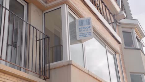 Apartment-for-sale-sign-hanging-at-the-building-window