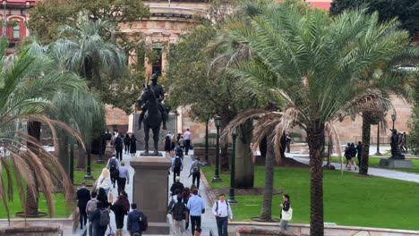 Large-crowd-of-office-workers-rushing-home-at-5pm,-walking-fast-towards-central-station-across-war-memorial-Anzac-square-at-downtown-Brisbane-city,-central-business-district,-Queensland,-Australia