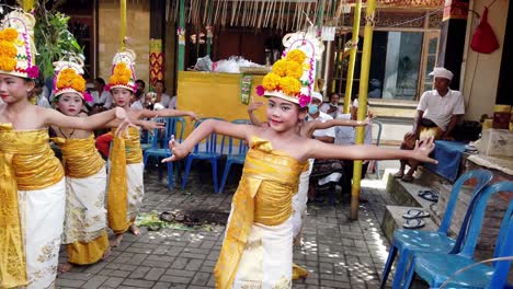 Dancing-Rejang-Dewa,-Young-Beautiful-Balinese-Girls-Performing-Ceremonial-Dance-for-The-Gods-in-a-Hindu-Temple-with-Costumes-and-Flower-Ornaments