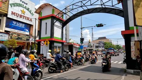 People-on-motorbikes-waiting-for-traffic-light-to-change-and-drive-in-Magelang,-Indonesia