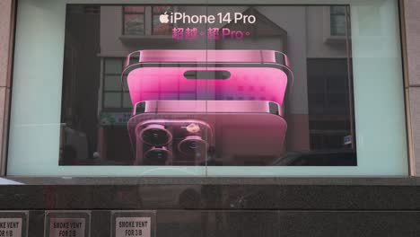 Chinese-pedestrians-wearing-face-masks-walk-past-a-commercial-advertisement-from-the-American-multinational-technology-company-Apple-showcasing-the-iPhone-14-Pro-smartphone-in-Hong-Kong