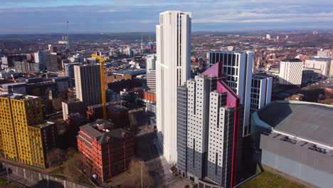 Aerial-Drone-Shot-looking-over-university-accommodation-skyscrapers-in-Leeds-City-Centre-with-colourful-yellow,-white,-purple,-orange-buildings-and-Leeds-arena-near-ring-road-West-Yorkshire-England-UK