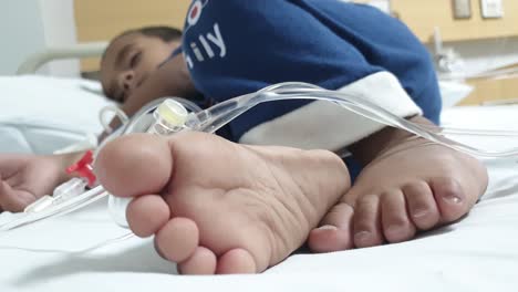Ein-Kritisch-Kranker-Pakistanischer-Junge,-Der-Mit-Pfeifen-In-Der-Hand-Im-Krankenhausbett-Schläft
