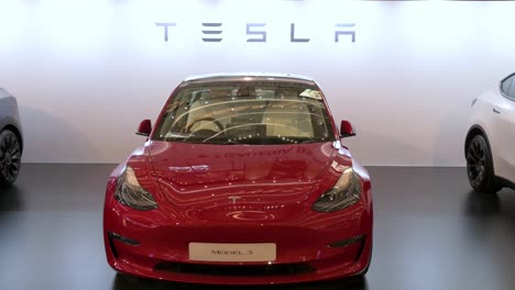 A-showroom-displaying-the-American-automobile-company,-Tesla-Motors,-electric-vehicles-such-as-model-X-car-in-red-at-a-retail-shopping-mall-in-Hong-Kong