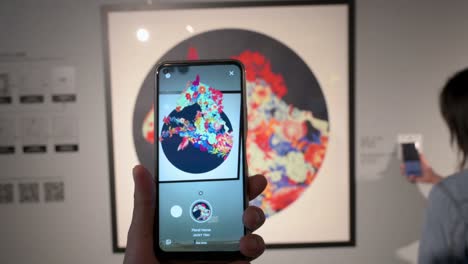 A-Chinese-visitor-uses-augmented-reality-with-a-smartphone-to-interact-with-artworks-at-the-Digital-Art-Fair-Asia-showcasing-upcoming-trends-such-as-Web-3