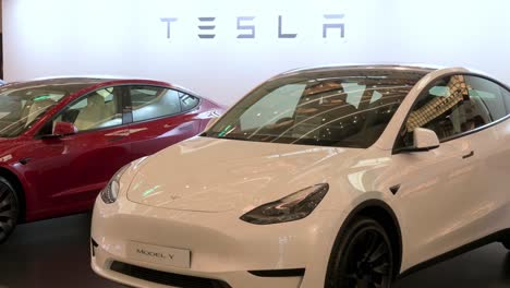 A-showroom-displaying-the-American-automobile-company,-Tesla-Motors,-electric-vehicles-such-as-model-Y-car-in-white-at-a-retail-shopping-mall-in-Hong-Kong