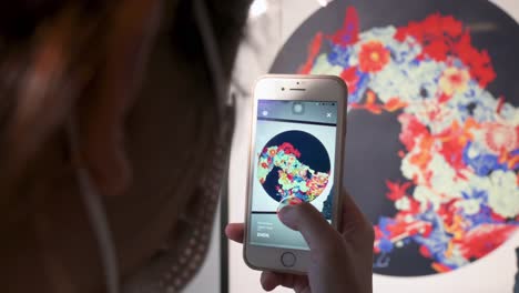 Eine-Chinesische-Besucherin-Nutzt-Augmented-Reality-Mit-Ihrem-Smartphone,-Um-Mit-Kunstwerken-Auf-Der-Digital-Art-Fair-Asia-Zu-Interagieren-Und-Zukunftstrends-Wie-Web-3-Zu-Präsentieren