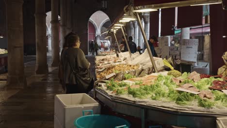 Slow-motion-pf-two-women-order-some-fresh-fish-in-local-market-in-Venice-Italy-in-the-morning