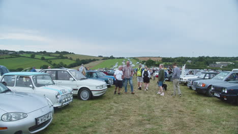 People-Walking-And-Looking-At-Vintage-Cars-Displayed-Outdoor-At-The-Great-Trethew-Rally-In-Liskeard,-UK