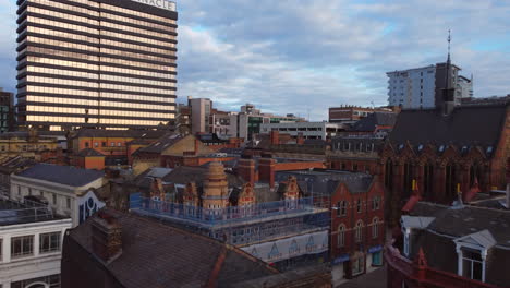 Aerial-drone-shot-panning-up-low-over-Leeds-City-Centre-Buildings-and-Pinnacle-building-on-sunny-morning