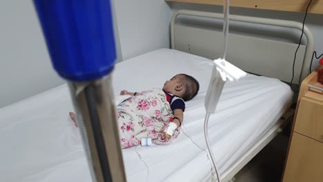 Background-Focus-On-Sick-Baby-In-Hospital-Bed-In-Pakistan-Attached-To-IV-Drip