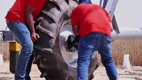 Workers-Carefully-Attaching-Large-Tyre-To-Center-Pivot-Irrigation-System-In-Rural-Farm-In-Sindh