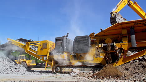 Slow-motion-shot-of-machinery-at-Sand-Mining-Plant-with-dust-during-sunny-day-and-blue-sky