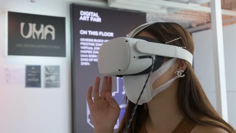 A-Chinese-art-visitor-uses-a-Virtual-Reality-headset-to-interact-with-an-immersive-artwork-at-the-Digital-Art-Fair-showcasing-upcoming-trends-such-as-Web-3