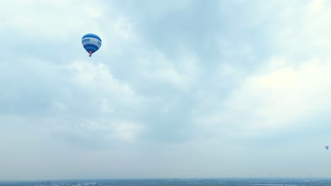 Blue-Hot-Air-Balloon-Flying-Across-Hendrik-ido-Ambacht-Under-Clouds