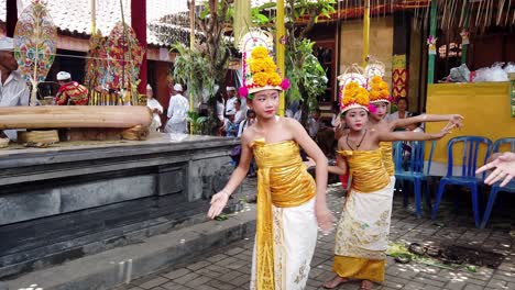 Girls-Dancing-Balinese-Traditional-Dance-Rejang-Dewa-with-Yellow-Costumes,-Bali-Indonesia,-in-a-Family-Temple-during-a-Praying-Ceremony-for-the-Gods