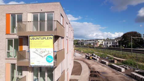 Luftschwenk-Um-Die-Baustelle-Informationsbanner-Von-Ubuntulein,-Das-Das-Gesamte-Immobilieninvestitionsprojekt-Der-Stadtentwicklung-In-Der-Nachbarschaft-Von-Noorderhaven-Enthüllt