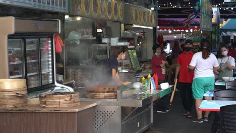 Vendor-selling-Dim-Sum-dumplings-in-large-steamer-baskets-to-awaiting-customers-at-Jalan-Alor,-Kuala-Lumpur,-Malaysia