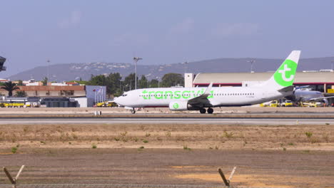 a-transavia-boeing-737-taxis-away-from-the-airport-building-after-passengers-have-boarded,-ready-to-take-off-from-faro-airport-in-portugal