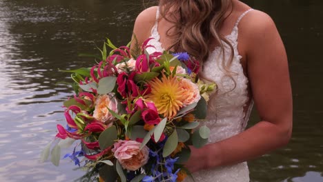 Beautiful-Bride-Is-Holding-A-Wedding-Colourful-Bouquet-Beside-Lake