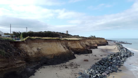 An-aerial-view-rises-from-the-beach-to-reveal-the-Norfolk-coastline-that-has-been-damaged-coastal-erosion-has-destroyed-a-road-and-threaten-nearby-homes