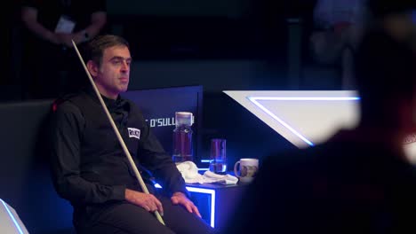 Ronnie-O'Sullivan,-World-Champion-and-World-Number-One-snooker-player,-is-seen-sitting-and-resting-between-sets-during-a-match-at-the-Hong-Kong-Masters-snooker-tournament-event