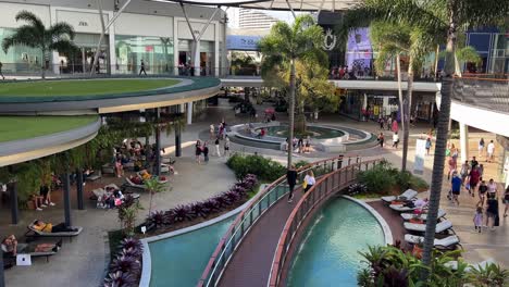 Tilt-up-shot-reveals-shoppers-strolling-and-window-shopping-at-pacific-fairs-shopping-centre-in-Gold-Coast,-Broadbeach-Waters-on-a-relaxing-and-sunny-afternoon,-Queensland,-Australia