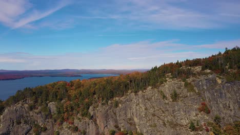 Aerial-slide-to-left-and-down-top-of-cliff-face-on-Kineo-Mountain-in-autumn
