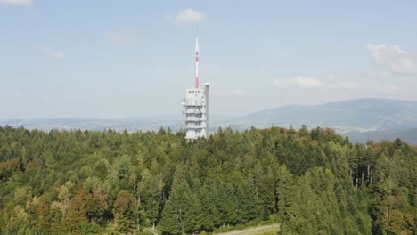 Aerial-reveal-of-landscape-behind-hill-with-communication-tower