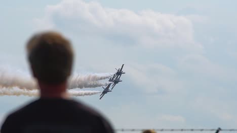 Spectators-watch-as-the-Blue-Angels-fly-low-near-the-crowd-line-while-rolling-left-in-a-diamond-formation-at-an-airshow-in-VA