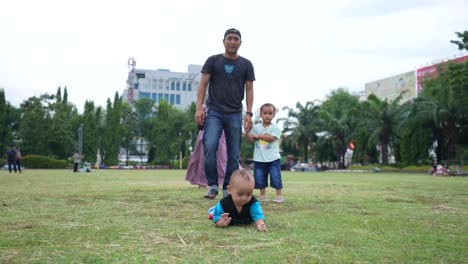 Sohn-Und-Vater-Spielen-Einen-Sehr-Süßen-Sohn,-Der-An-Einem-Sonnigen-Sommertag-Am-Wochenende-In-Simpang-Lima-Park-Semarang-Herunterläuft