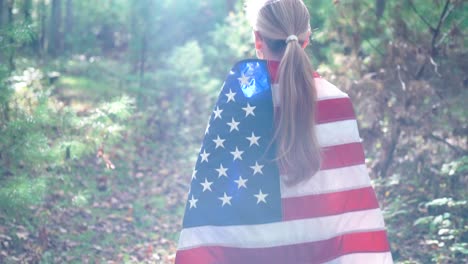 Blonde-woman-with-hair-in-a-ponytail-walking-with-a-US-flag-draped-around-her