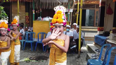 Balinesischer-Rejang-Dewa-Tanz,-Jungfräuliche-Mädchen,-Die-Im-Tempel-Tanzen-Und-Den-Göttern-Opfern,-Gelbe-Kleider-Und-Blumenkronen-Tragen