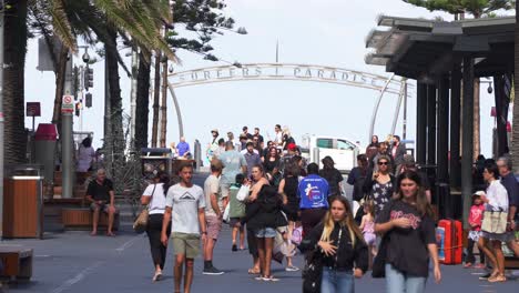 Tourist-hotspot,-busy-downtown-Gold-coast-city-crowded-with-people-walking-on-Cavill-avenue-with-surfers-paradise-sign-in-the-background-at-the-esplanade,-Queensland,-Australia