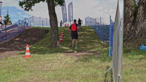 Triathlon-runners-running-uphill,-low-angle-view-from-behind,-Smiltene,-Latvia