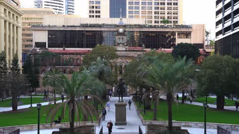 Wide-shot-at-Anzac-square-with-pedestrians-walking-and-strolling-across-the-park-and-war-memorial-the-scout-sculpture-in-the-center-at-downtown-Brisbane-city,-central-business-district